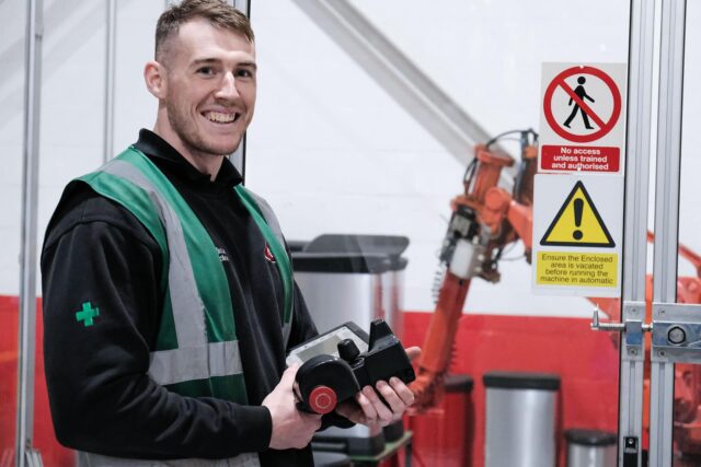 An engineer wearing high vis jacket smiling.