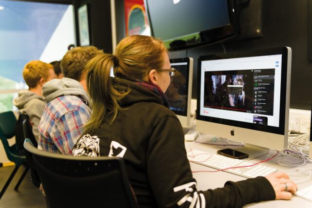 Students sit at computers in the media suite.