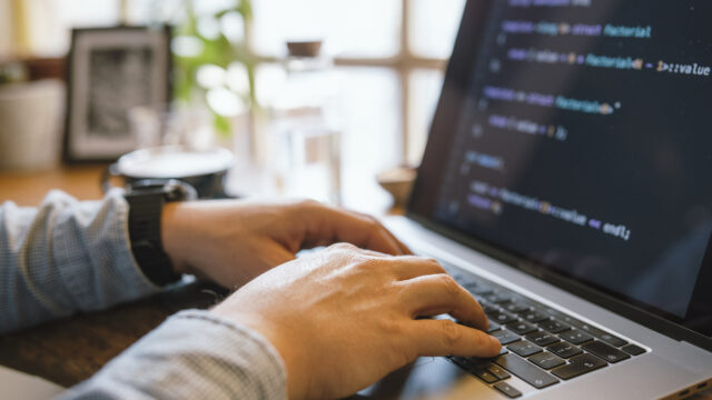 Hands typing on a laptop.