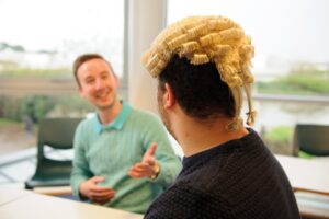 The back of a student's head who is wearing a judicial wig.