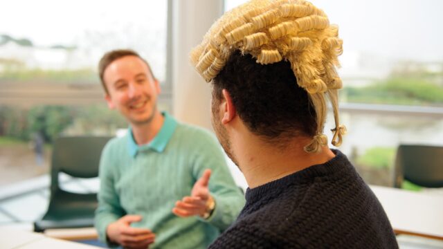 The back of a student's head who is wearing a judicial wig.