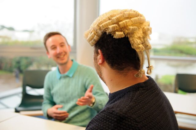 The back of a student's head who is wearing a judicial wig.