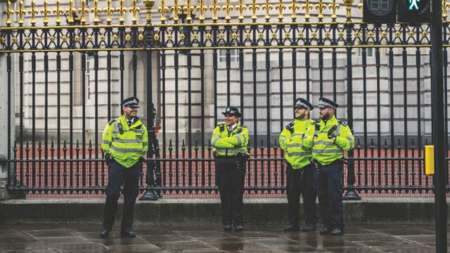 Four police officers stood outside the gates of Buckingham Palace.