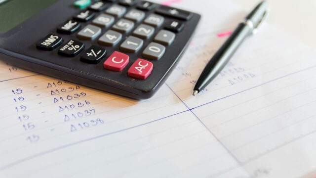 Close up of a calculator and pen.