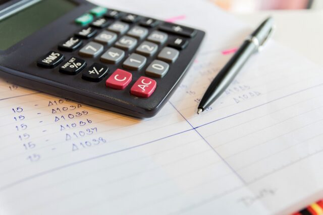 Close up of a calculator and pen.