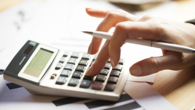 Closeup of a hand using a calculator.