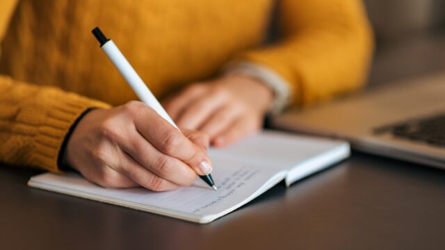 Writing in notebook. Close-up.