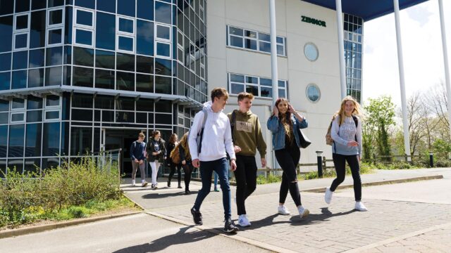 Students walking out into the sunshine from the Zennor building at Penwith College.