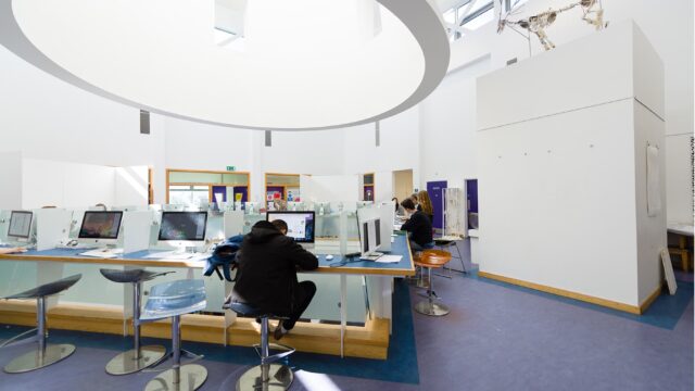 Students sit at Mac computers in a communal spaces. Excellent facilities at Truro and Penwith College.