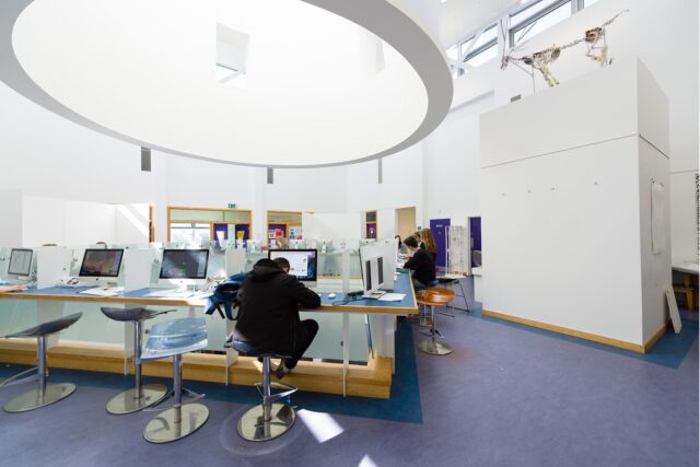 Students sit at Mac computers in a communal spaces. Excellent facilities at Truro and Penwith College.