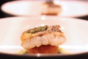 Cooked fish on a white plate.