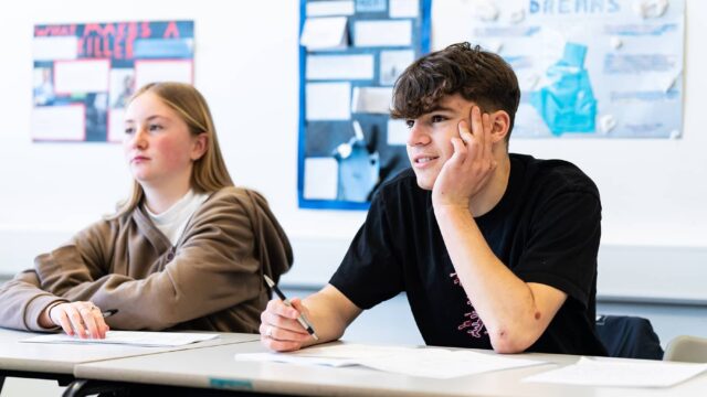 Two students sat at classroom tables.