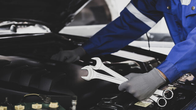Mechanic works on the engine of the car in the garage.