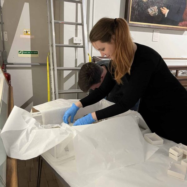 Jeni is unpacking a large box full of artefacts.
