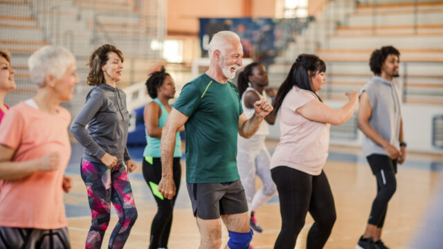 Large group of people dancing at Zumba class.