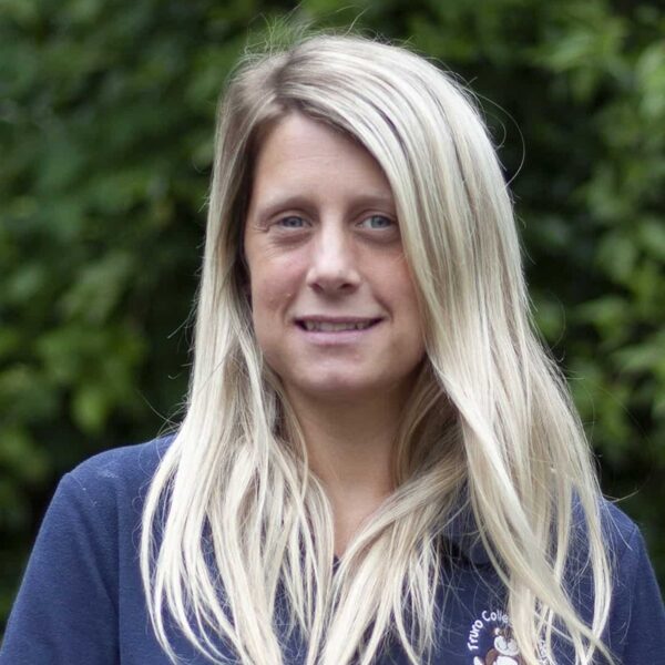 A photo of Kim, she is wearing a blue polo shirt with the nursery logo on it.