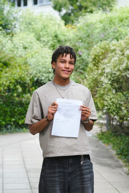 Louis holds up his results and smiles.