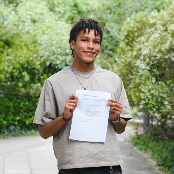 Louis holds up his results and smiles.
