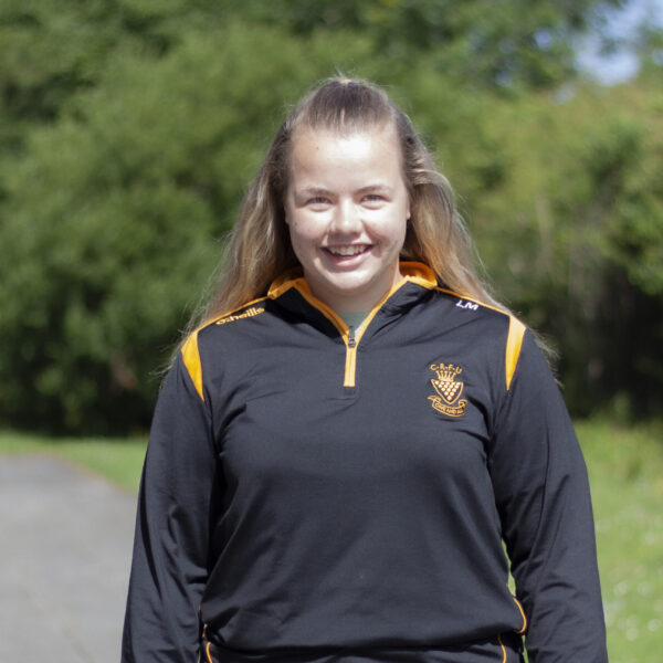 Lucie Mills in a rugby top stood outside.
