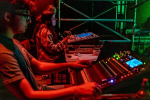 Students use technical equipment backstage.