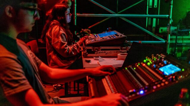 Students use technical equipment backstage.