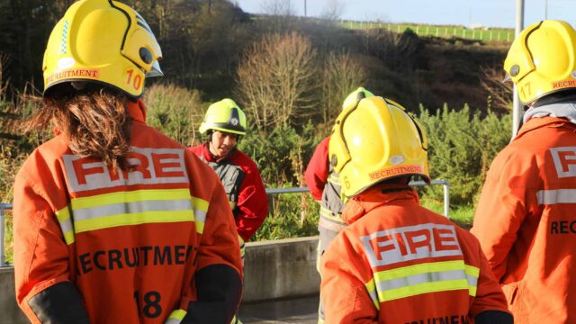 People wearing fire fighter helmets and uniform.
