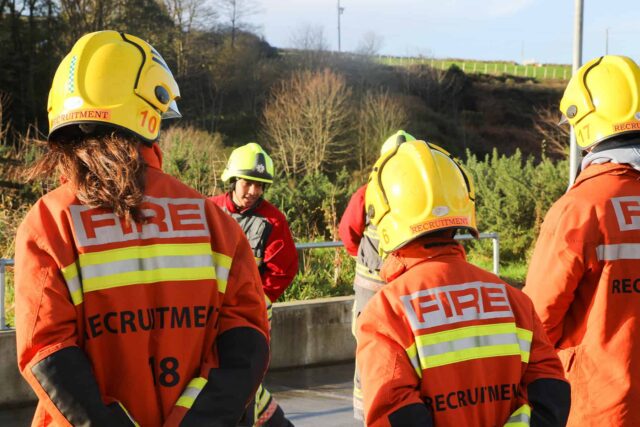 People wearing fire fighter helmets and uniform.