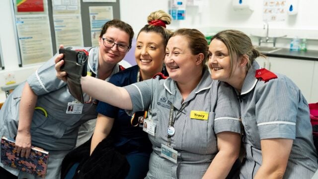 A group of nursing students take a selfie in their uniforms within a classroom at the University Centre Truro and Penwith.