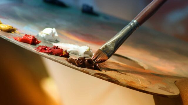 A close up of a paintbrush and an artist's pallette.