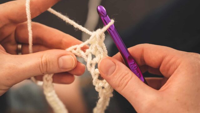 Close-up of hands crocheting.