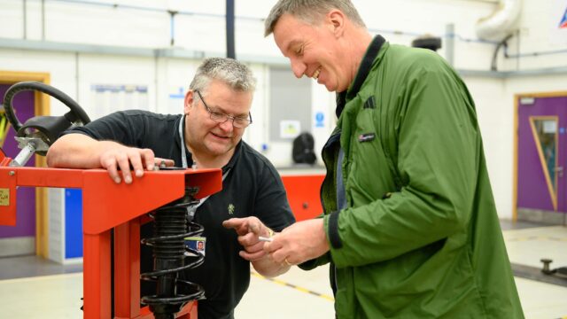 Two men in the garage at the college.