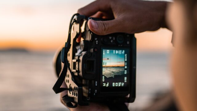 Looking through a camera screen to a sunset on the beach.
