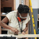 Paola Mara in construction gear and doing woodwork