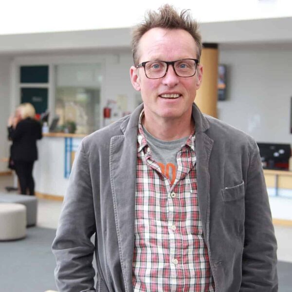 Peter is stood in the Fal foyer on a bright day.