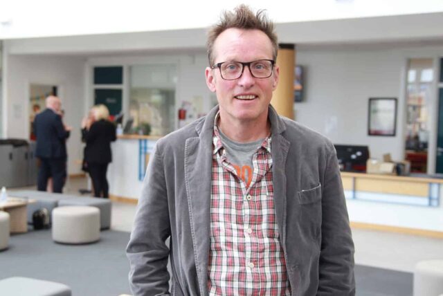 Peter is stood in the Fal foyer on a bright day.