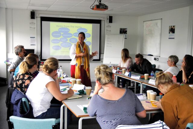 A classroom with mature students and a teacher.