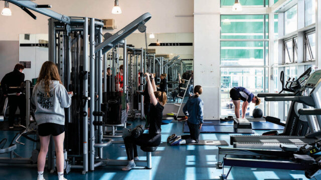 A gym at Truro College. Students are using weight machines and doing cardio fitness.