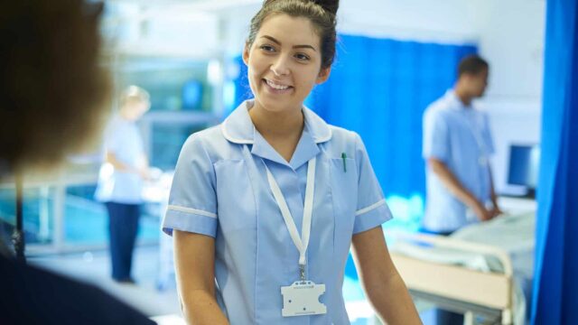 A nurse smiles at an unrecognisable person.