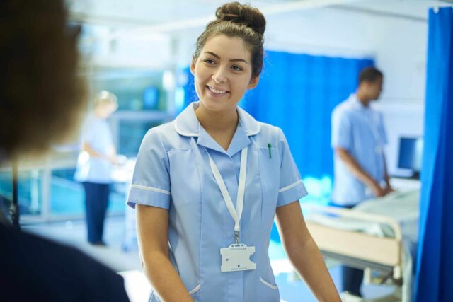 A nurse smiles at an unrecognisable person.