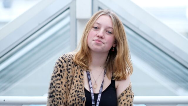 Rochie is wearing an animal print cardigan and a student lanyard.