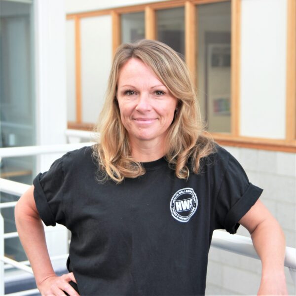 A portrait photo of Sheona, head of the Health Wellbeing and Sport department. Sheona is wearing a black t shirt with the HWS logo on it.