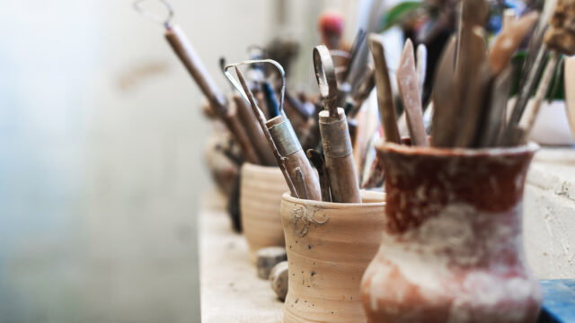 Close up photo of tools for ceramics on window sill.
