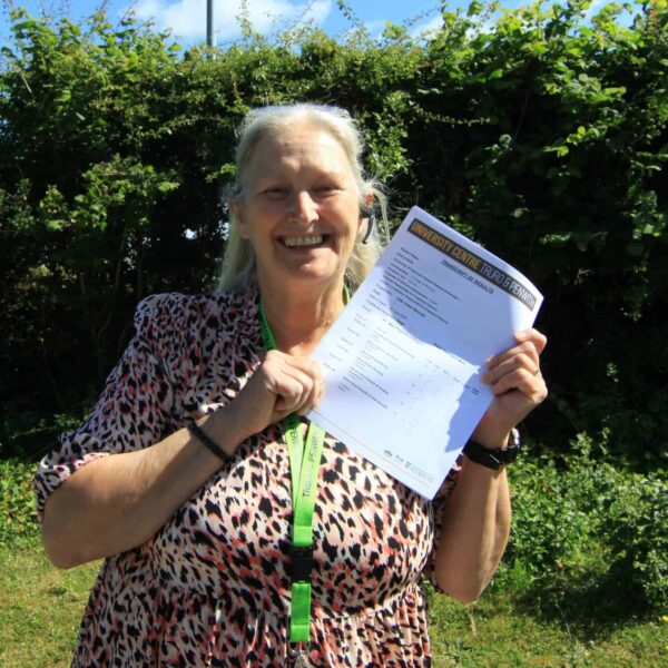 Sue stood outside holding up her results.