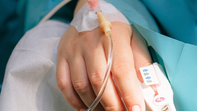 A close up of a hand with a tube attached to it.