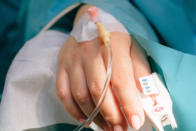 A close up of a hand with a tube attached to it.