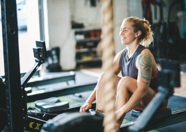 A woman in a gym using a rowing machine.