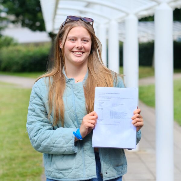 Bella holds up her results and smiles.