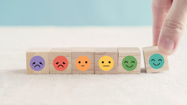 Hand choosing happy smile face wooden block.
