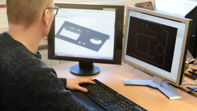 Design engineer at the PC in the metal industry in the office.
