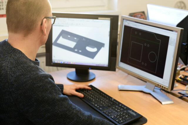 Design engineer at the PC in the metal industry in the office.